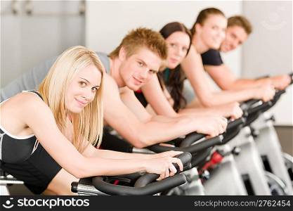Fitness group of people on bicycle doing spinning at gym