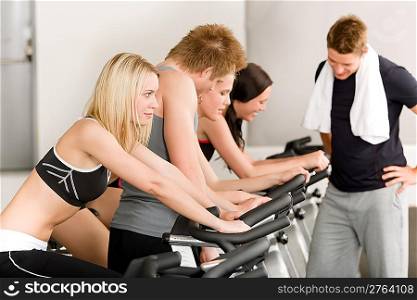 Fitness group of people on bicycle doing spinning at gym