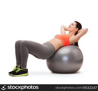 fitness, healcare and dieting concept - smiling teenage girl doing exercise on fitness ball