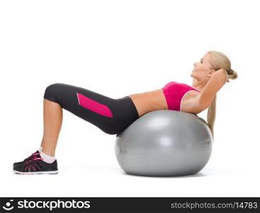 fitness, healcare and dieting concept - young woman doing exercise on fitness ball