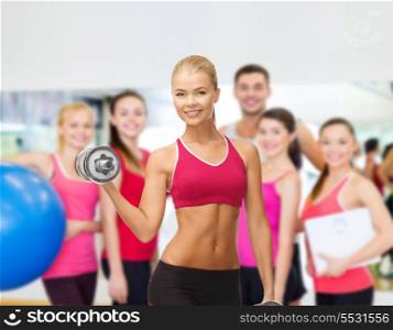 fitness, health and diet concept - young sporty woman with heavy steel dumbbells