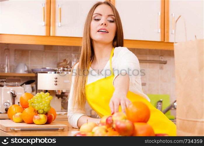Fitness health fruits diet concept. Hungry lady eating. Young gorgeous female cook in kitchen preparing healthy food.. Hungry lady eating.