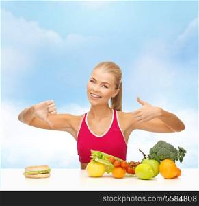 fitness, healthcare and diet concept - smiling woman with fruits and hamburger showing good and bad signs