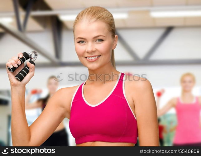 fitness, healthcare and dieting concept - beautiful sporty woman with hand expander