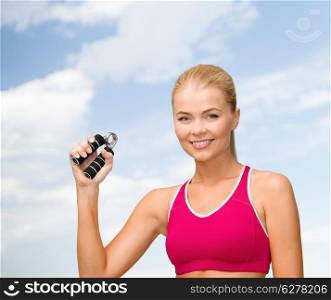 fitness, healthcare and dieting concept - beautiful sporty woman with hand expander