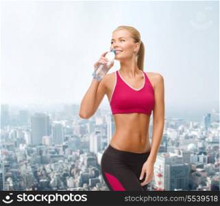 fitness, healthcare and dieting concept - smiling sporty woman with bottle of water