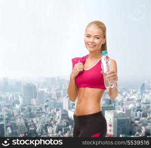 fitness, healthcare and dieting concept - smiling sporty woman with bottle of water and towel