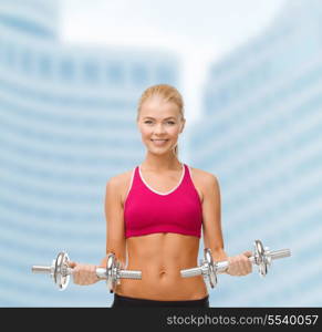 fitness, healthcare and dieting concpt - young sporty woman with heavy steel dumbbells