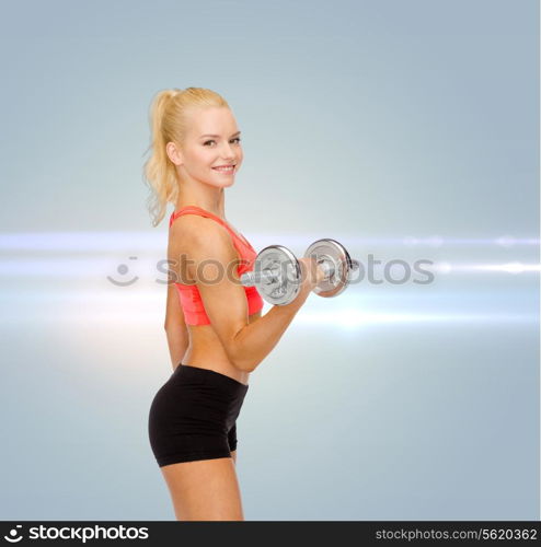 fitness, healthcare and exercise concept - young sporty woman with heavy steel dumbbell