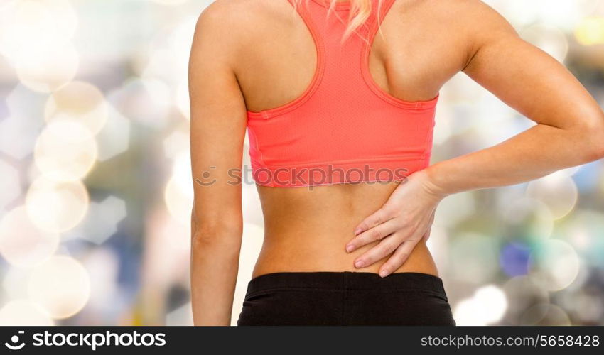 fitness, healthcare and medicine concept - close up of sporty woman touching her back