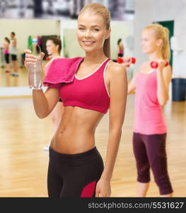 fitness, heatl and diet concept - sporty woman with bottle of water and towel