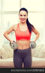 fitness, home and diet concept - smiling girl exercising with heavy dumbbells at home