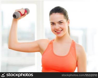 fitness, home and diet concept - smiling redhead girl exercising with heavy dumbbell at home