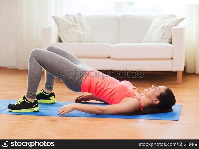 fitness, home and diet concept - smiling teenage girl doing exercise for legs and buttocks on floor at home