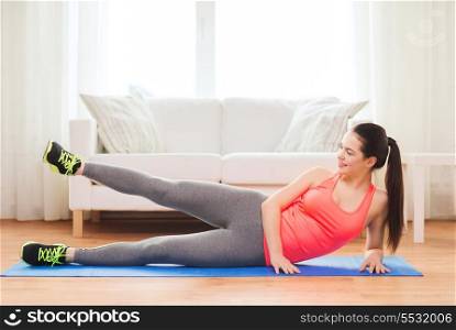 fitness, home and diet concept - smiling teenage girl doing exercise for legs on floor at home