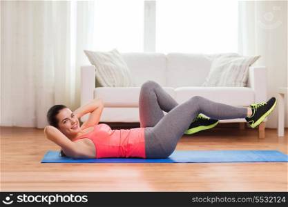 fitness, home and diet concept - smiling teenage girl doing exercise on floor at home