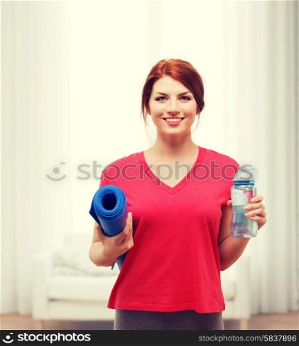 fitness, home and diet concept - smiling teenage girl with bottle of water and yoga mat after exercising at home