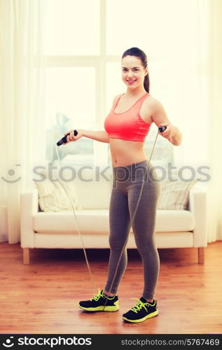 fitness, home and diet concept - smiling teenage girl with skipping rope at home