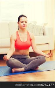 fitness, home and diet concept - smiling teenager meditating at home