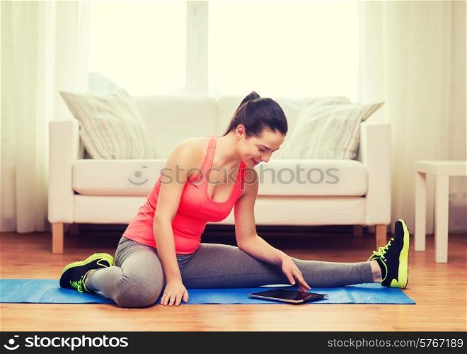 fitness, home, technology and diet concept - smiling teenage girl streching on floor with tablet pc computer at home