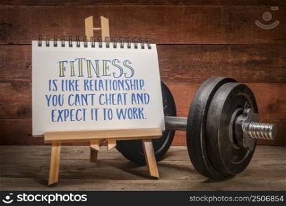 Fitness is like relationship. You can’t cheat and expect it to work. Inspirational slogan on an easel sign with a heavy dumbbell. Exercise and training concept.