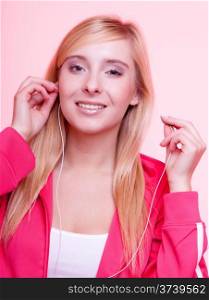 fitness lifestyle concept - woman doing sports and listening to music. Teen girl with headphones use mp3 music player relax gym on pink background