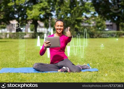 fitness, park, technology, gesture and people concept - smiling african american woman with tablet pc showing thumbs up outdoors