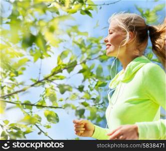 fitness, people and healthy lifestyle concept - happy young female runner jogging outdoors