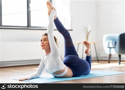 fitness, people and healthy lifestyle concept - young woman doing half bow pose at yoga studio. young woman doing half bow pose at yoga studio