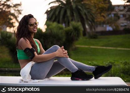 Fitness runner woman relaxing in the city park