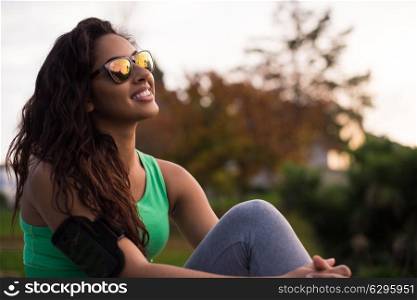 Fitness runner woman relaxing in the city park