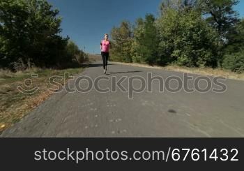 Fitness running woman jogging during outdoor workout along country road wide angle