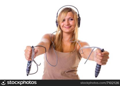 Fitness, slimming, loosing weight concept. Happy blonde woman holding skipping rope, wearing big headphones and sportswear. Studio shot isolated.. Blonde woman holding skipping rope wearing headphones