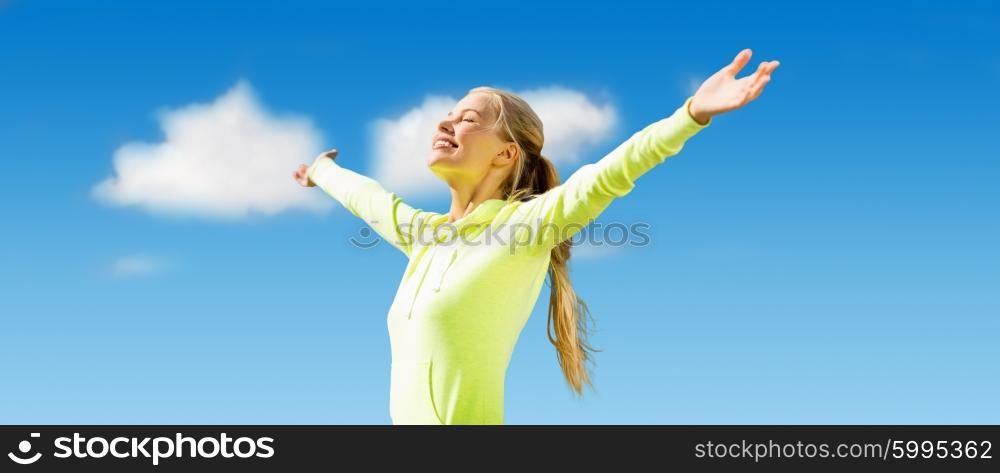 fitness, sport, achievement, people and emotions concept - happy sporty woman enjoying sun and freedom over blue sky and clouds background