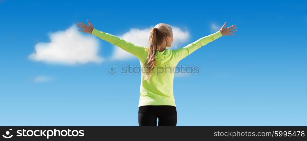 fitness, sport, achievement, people and emotions concept - happy sporty woman enjoying sun and freedom over blue sky and clouds background from back