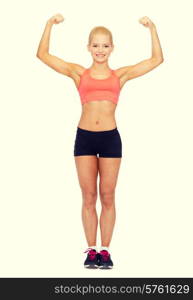 fitness, sport and diet concept - smiling sporty woman flexing her biceps