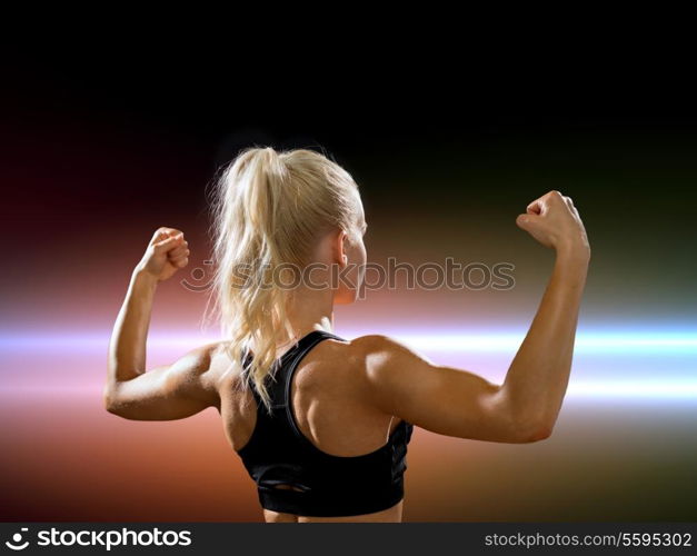 fitness, sport and diet concept - sporty woman form the back flexing her biceps