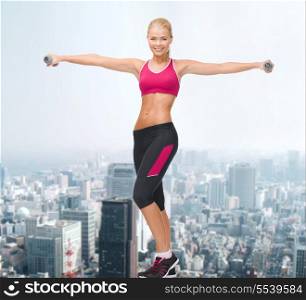 fitness, sport and dieting concept - young sporty woman with light dumbbells