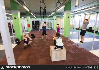 fitness, sport and exercising concept - group of people training with different equipment in gym. group of people exercising in gym