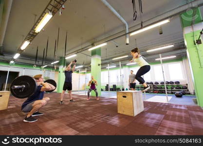 fitness, sport and exercising concept - group of people training with different equipment in gym. group of people exercising in gym. group of people exercising in gym