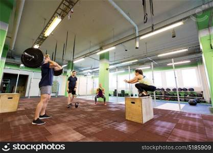 fitness, sport and exercising concept - group of people training with different equipment in gym. group of people exercising in gym