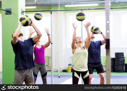 fitness, sport and exercising concept - group of people with medicine balls training in gym. group of people with medicine ball training in gym