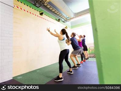 fitness, sport and exercising concept - group of people with medicine balls training in gym. group of people with medicine ball training in gym. group of people with medicine ball training in gym