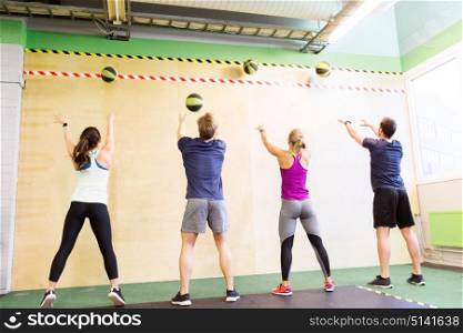 fitness, sport and exercising concept - group of people with medicine balls training in gym. group of people with medicine ball training in gym
