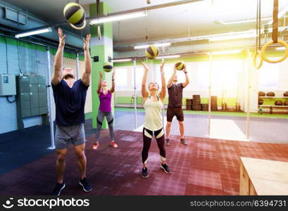 fitness, sport and exercising concept - group of people with medicine balls training in gym. group of people with medicine ball training in gym