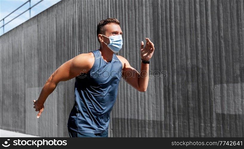 fitness, sport and health concept - young man in medical mask running outdoors. young man in medical mask running outdoors