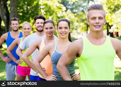 fitness, sport and healthy lifestyle concept - group of happy friends or sportsmen at summer park. group of happy friends or sportsmen at summer park
