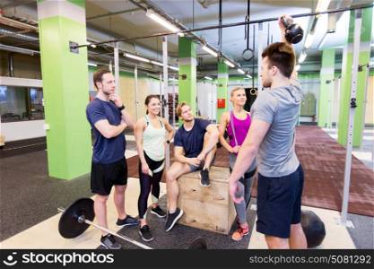 fitness, sport and healthy lifestyle concept - group of happy people with different sports equipment talking in gym. group of friends with sports equipment in gym