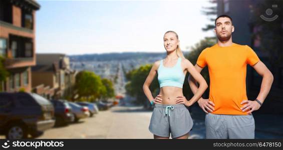 fitness, sport and healthy lifestyle concept - happy couple exercising in summer over san francisco city background. happy couple doing sports at san francisco city. happy couple doing sports at san francisco city