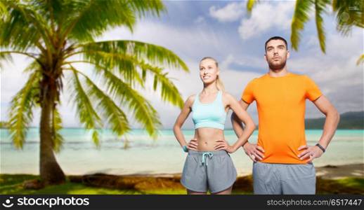 fitness, sport and healthy lifestyle concept - happy couple exercising over tropical beach background in french polynesia. happy couple exercising at summer. happy couple exercising at summer